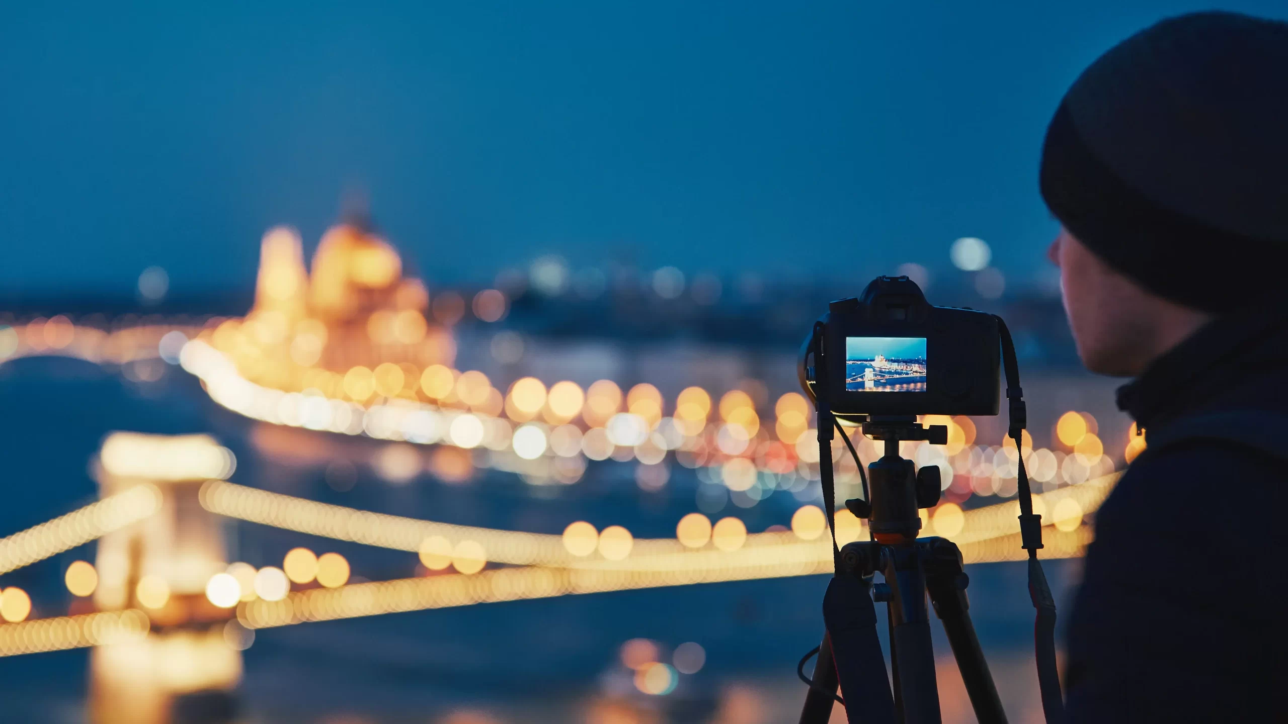 A person photographing a city at night